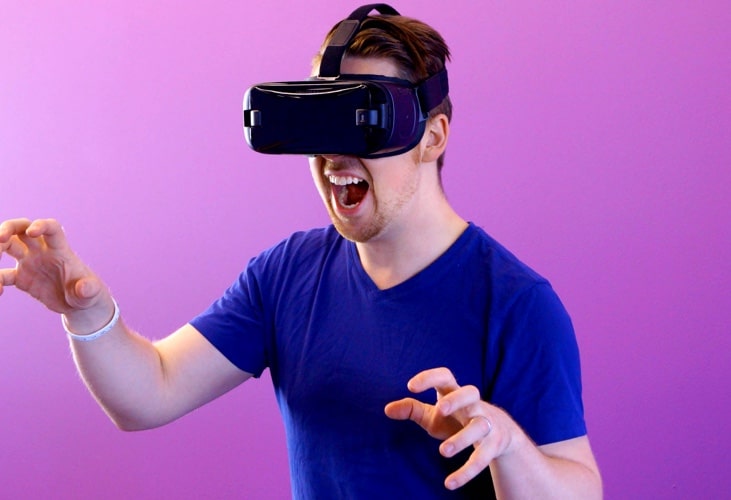 A man with a virtual reality helmet on playing a game.